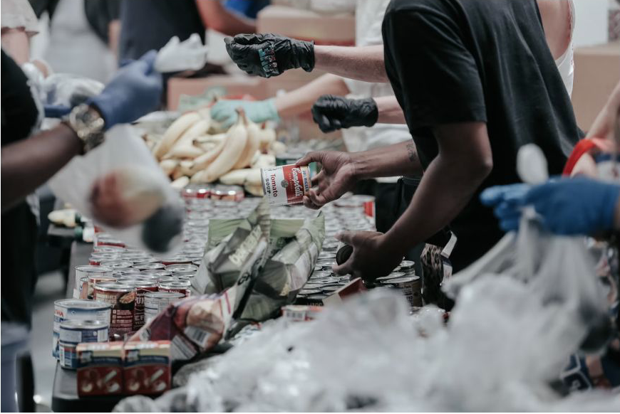 Volunteers coordinating food resources together at a community distribution table