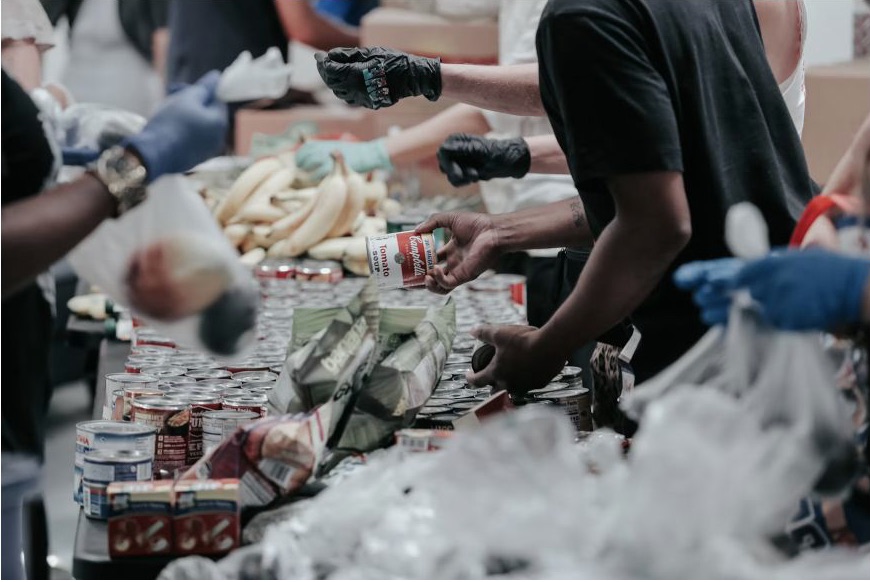 Volunteers coordinating food resources together at a community distribution table